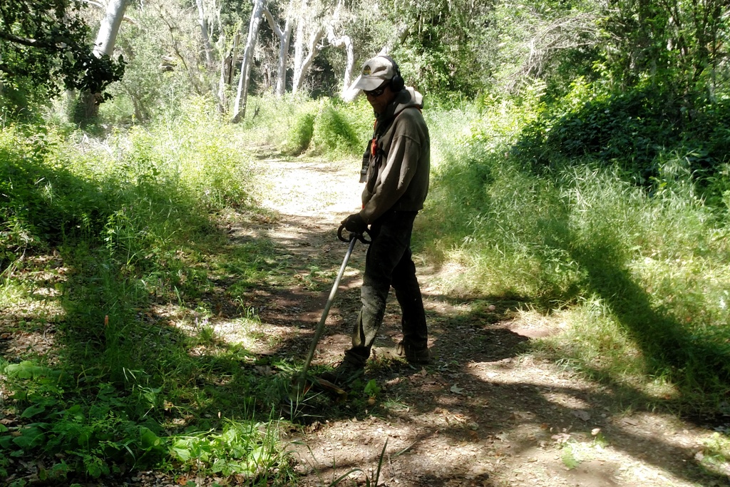 Greg weed-eating the path to the creek.